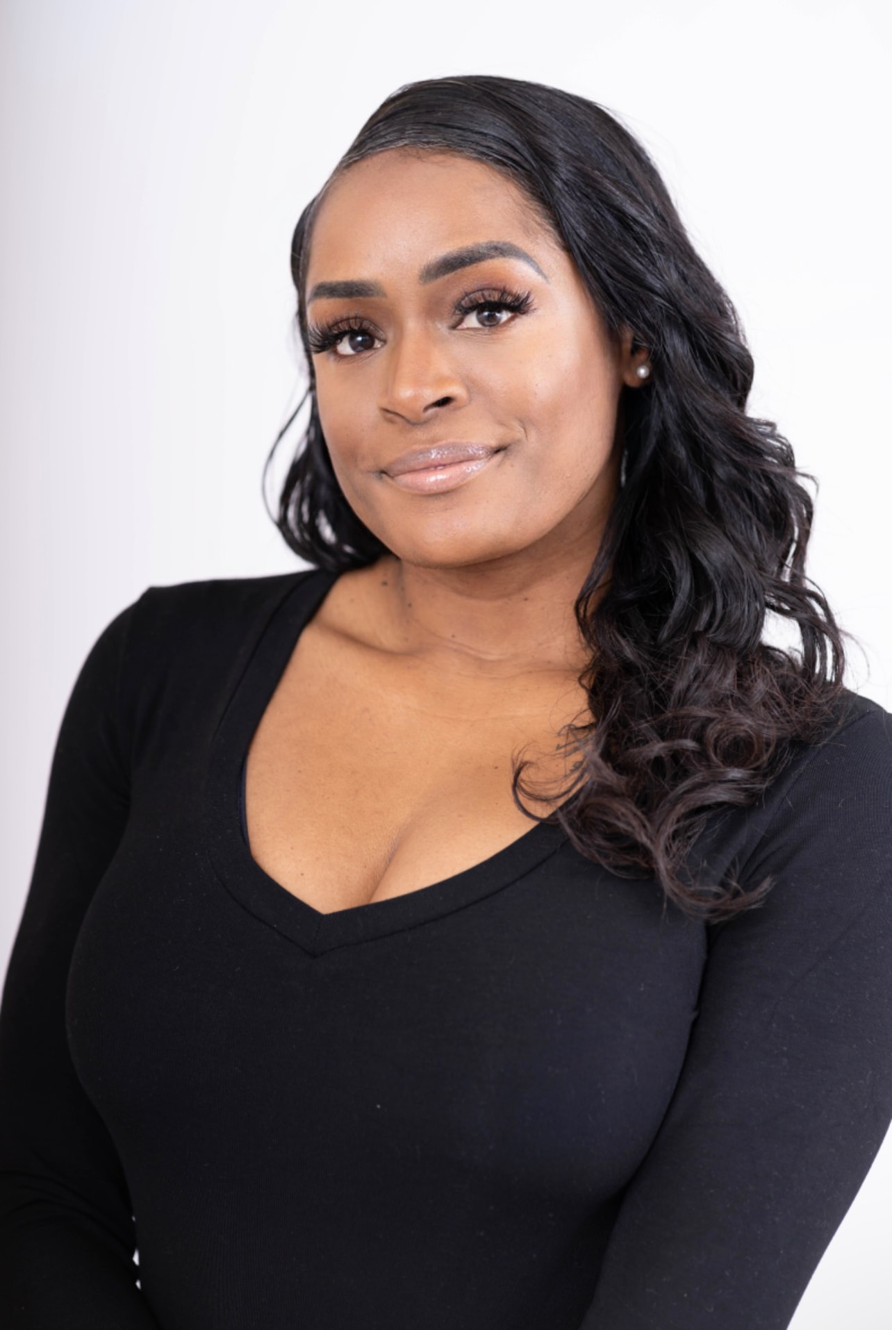 Aubree Bravo — black v-neck, wavy hair, direct gaze