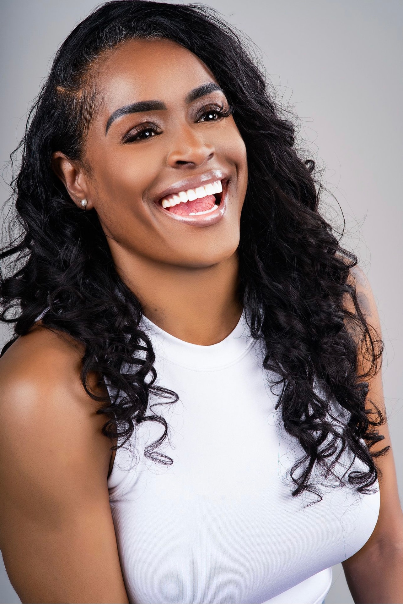 Aubree Bravo — white tank, big laugh, curly hair