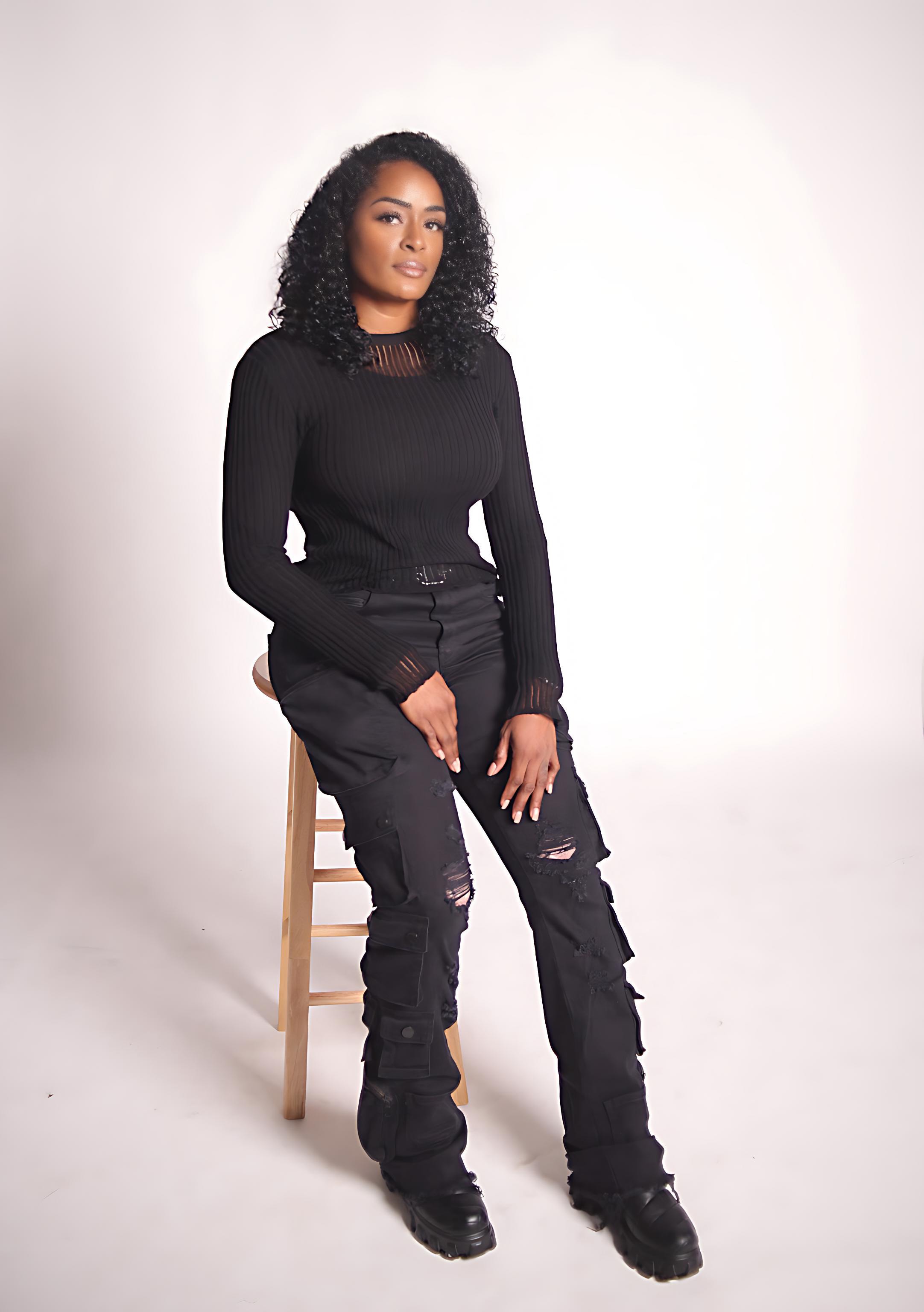 Aubree Bravo — black ribbed top, seated on stool